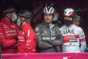 Los ciclistas del Giro esperando bajo la lluvia la decisión final de la etapa 19 del Giro d'Italia 2020